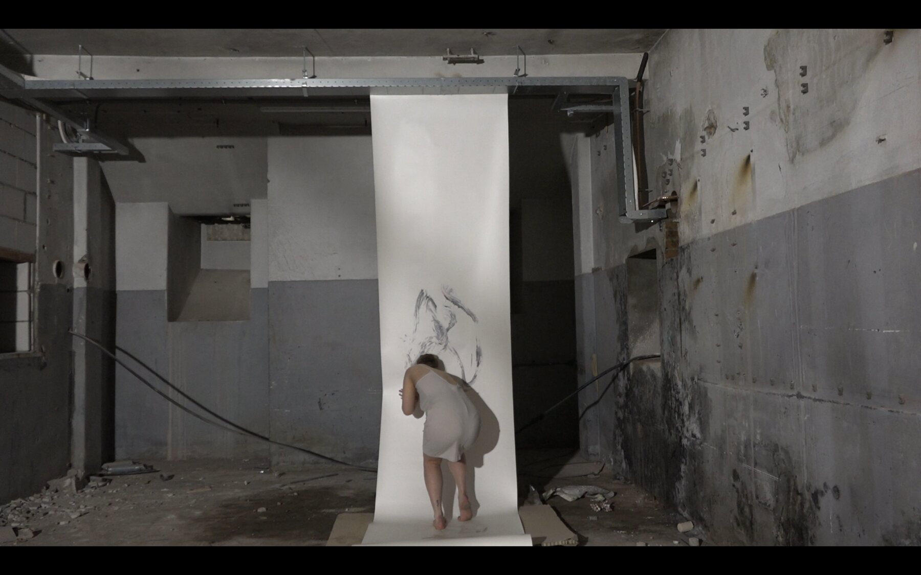 A body marking a suspended white surface in an industrial interior