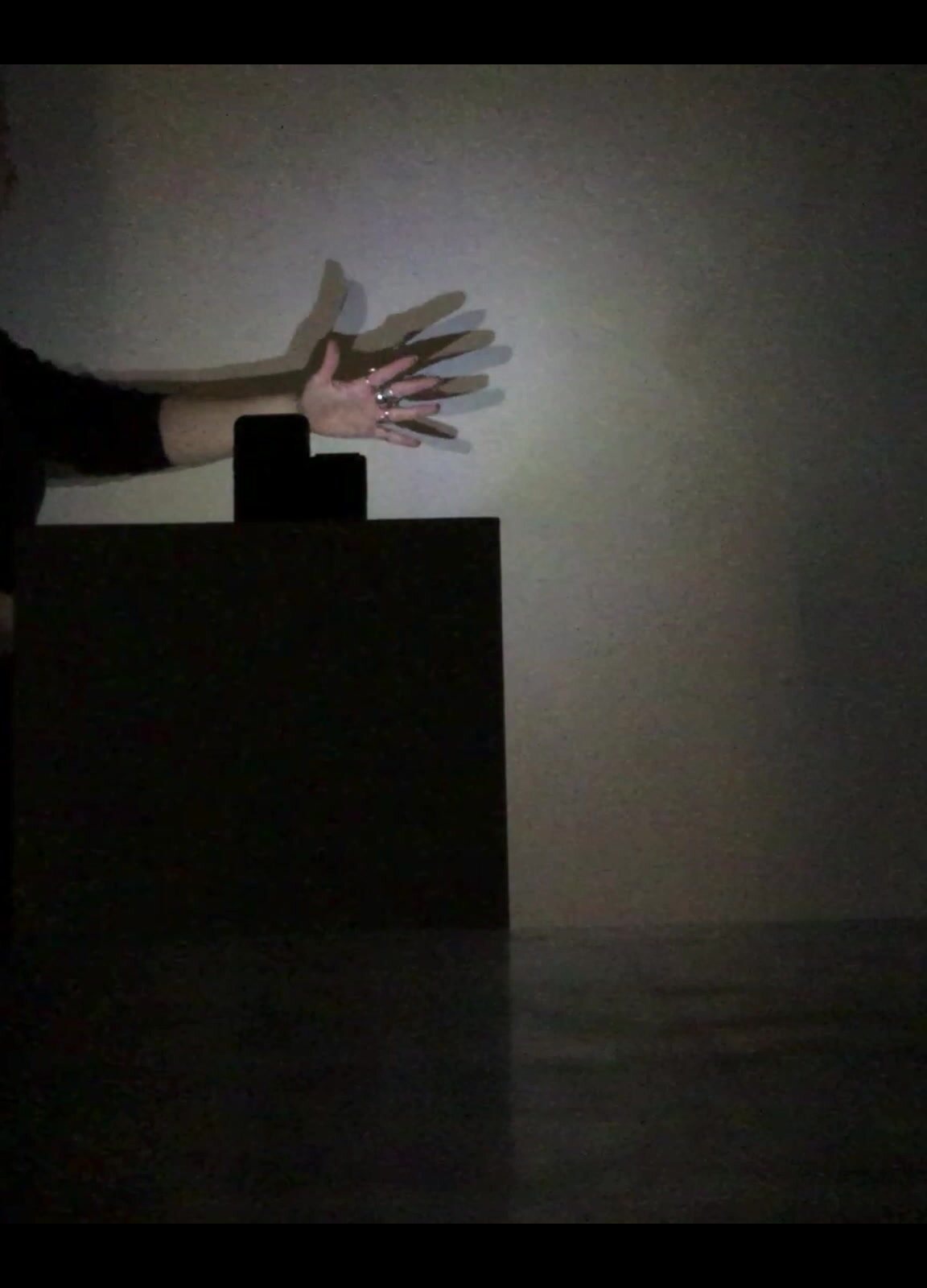 Hand shadows moving across a luminous white surface